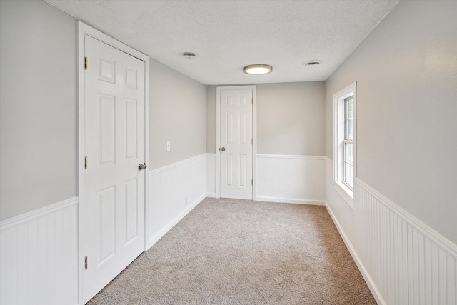 empty room featuring a textured ceiling and carpet floors