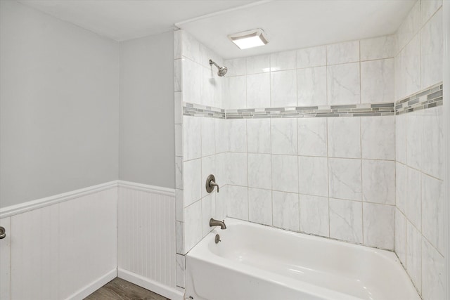 bathroom with tiled shower / bath combo and hardwood / wood-style flooring