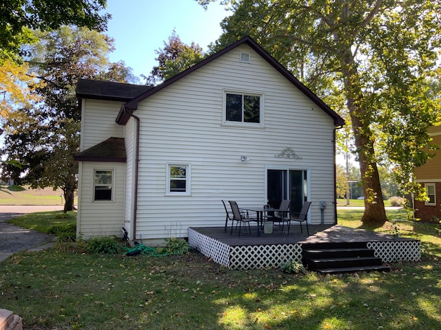 rear view of house with a wooden deck and a yard