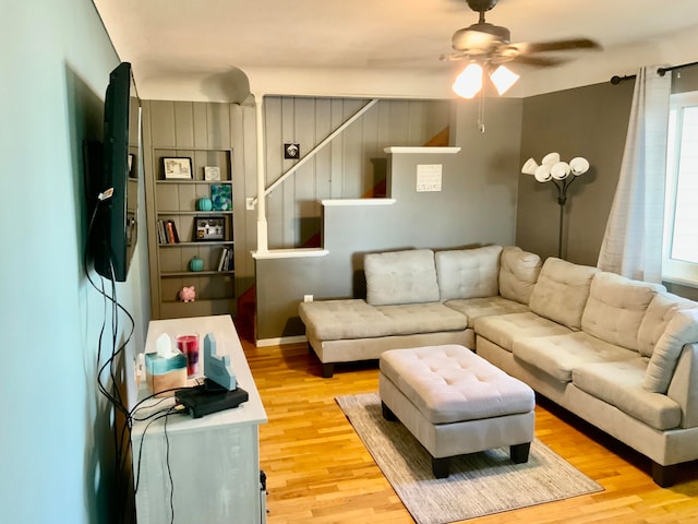 living room with light hardwood / wood-style floors and ceiling fan