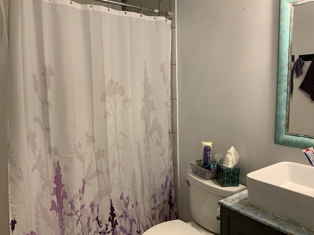 bathroom featuring a shower with curtain, vanity, and toilet