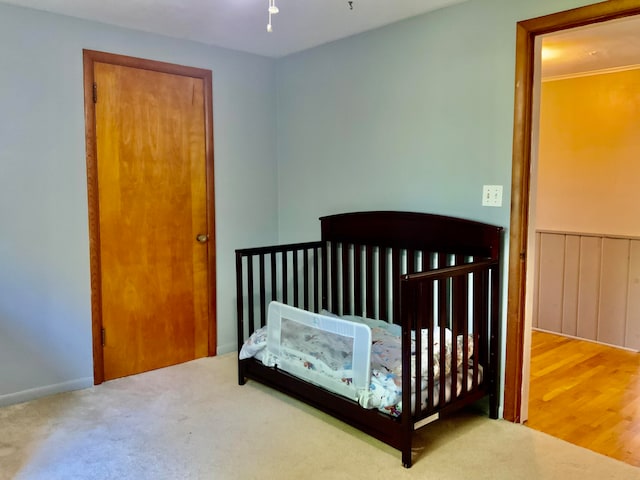 bedroom featuring hardwood / wood-style floors and a nursery area