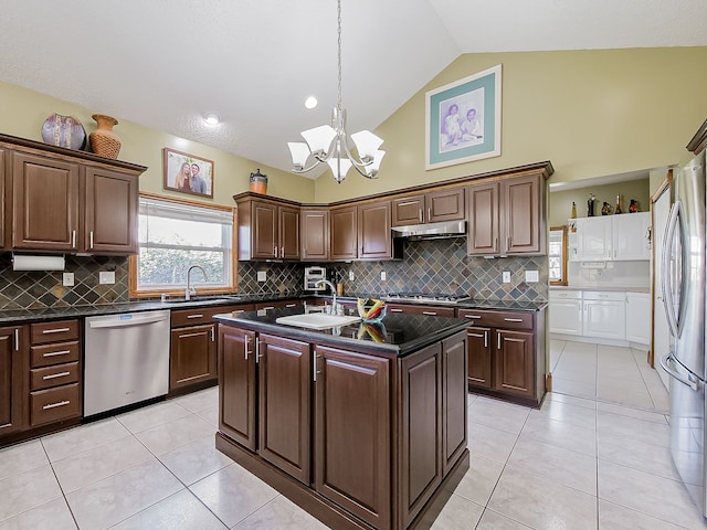 kitchen featuring backsplash, stainless steel appliances, a center island with sink, and sink