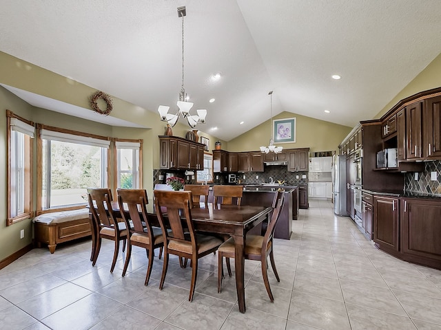 tiled dining area with high vaulted ceiling, a chandelier, and a textured ceiling