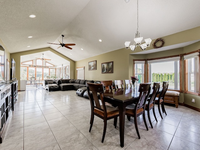 dining space with ceiling fan with notable chandelier, light tile patterned floors, a textured ceiling, and vaulted ceiling