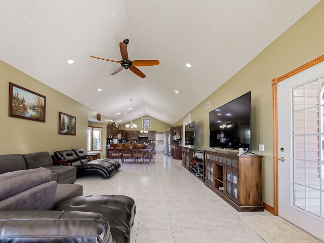 tiled living room featuring a textured ceiling, ceiling fan, a healthy amount of sunlight, and lofted ceiling