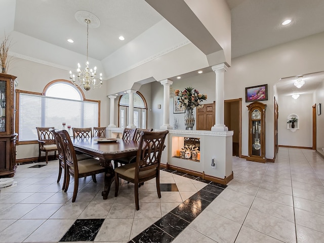 dining space featuring decorative columns, light tile patterned floors, a high ceiling, and a notable chandelier