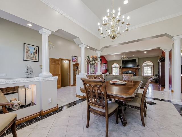 tiled dining space with a towering ceiling, ceiling fan with notable chandelier, and ornamental molding