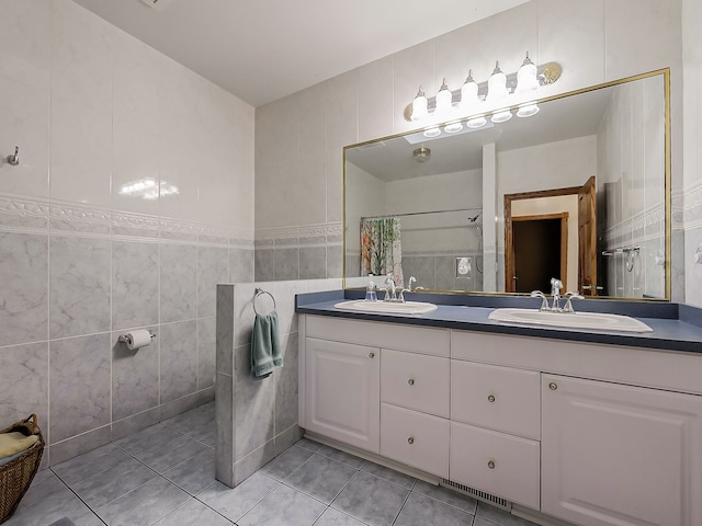 bathroom with tile patterned floors, vanity, curtained shower, and tile walls