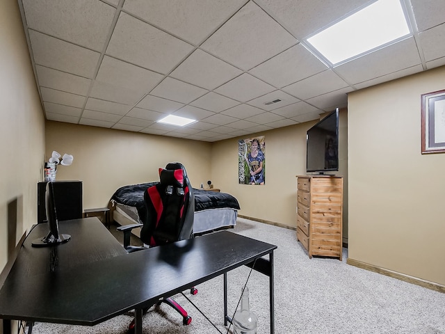 carpeted office with a paneled ceiling