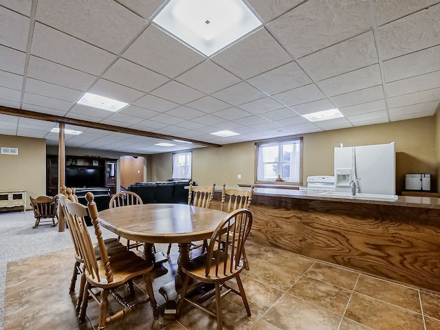 dining space featuring tile patterned flooring, a paneled ceiling, and sink