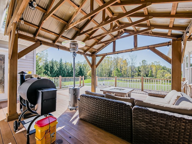 deck featuring a gazebo, grilling area, and an outdoor living space with a fire pit