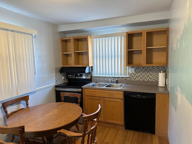 kitchen featuring sink, backsplash, light hardwood / wood-style floors, and black appliances