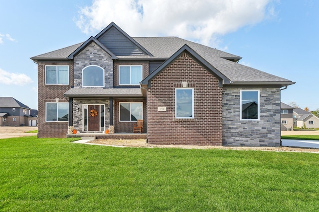 view of front facade with stone siding, brick siding, a front lawn, and a shingled roof