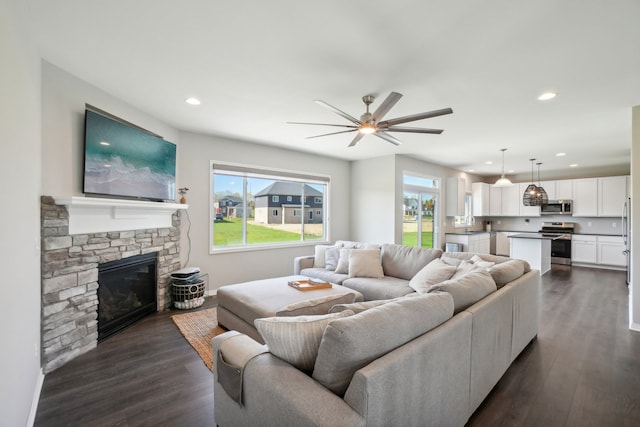 living room with recessed lighting, a fireplace, dark wood-type flooring, and ceiling fan