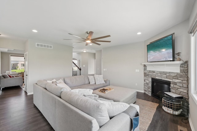 living area with stairway, visible vents, recessed lighting, a stone fireplace, and dark wood-type flooring