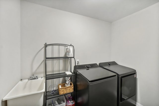 laundry area with a sink, laundry area, and washer and clothes dryer