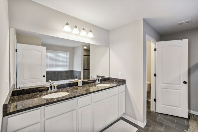 bathroom with visible vents, a bathing tub, baseboards, and a sink