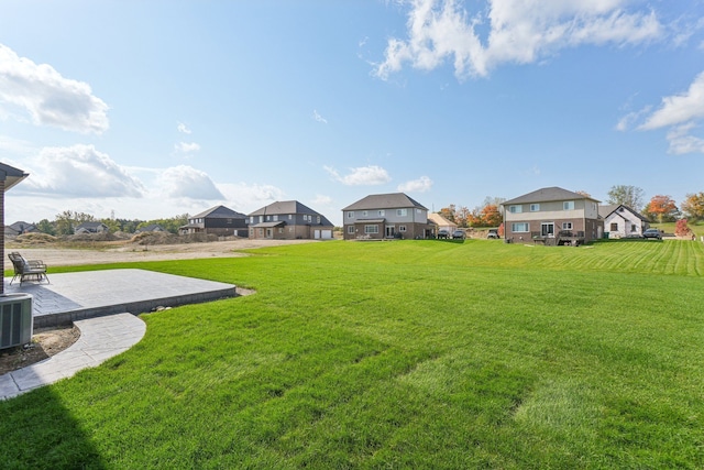 view of yard featuring a residential view, a patio, and central AC