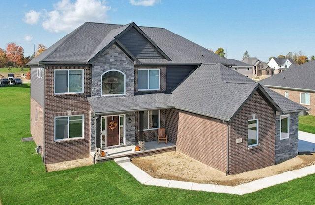 view of front facade featuring stone siding, a front yard, and a shingled roof