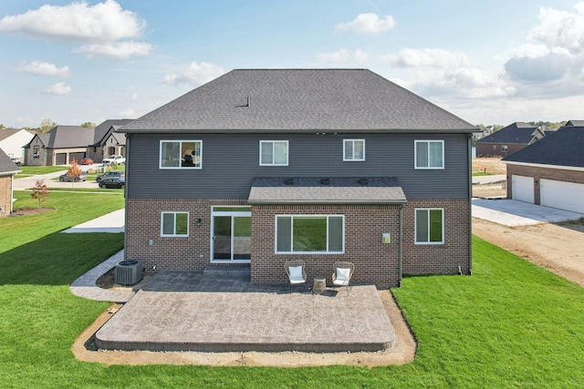 rear view of house with a patio, roof with shingles, a yard, central air condition unit, and brick siding