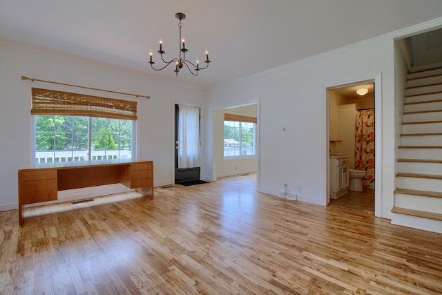 interior space featuring a wealth of natural light, light hardwood / wood-style flooring, a chandelier, and ornamental molding