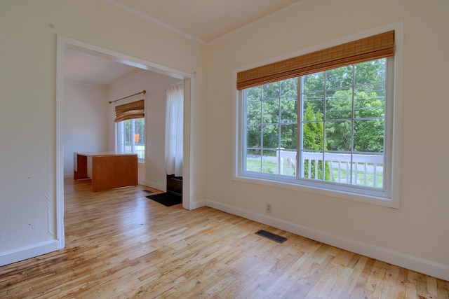 unfurnished room with light hardwood / wood-style floors and crown molding