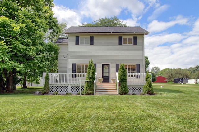 back of property featuring a wooden deck and a yard