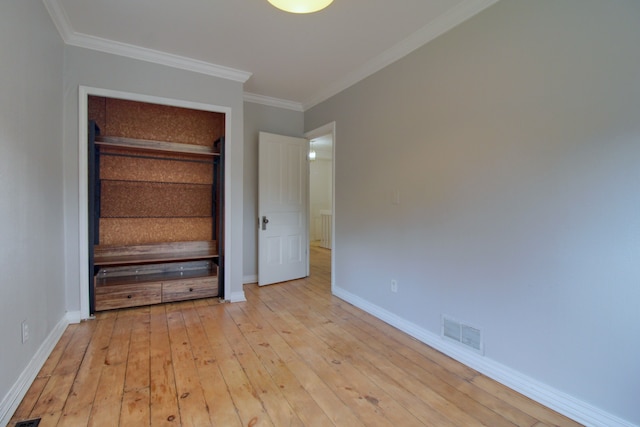 unfurnished bedroom featuring a closet, light hardwood / wood-style flooring, and ornamental molding