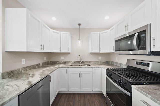 kitchen featuring white cabinets, sink, hanging light fixtures, dark hardwood / wood-style floors, and stainless steel appliances