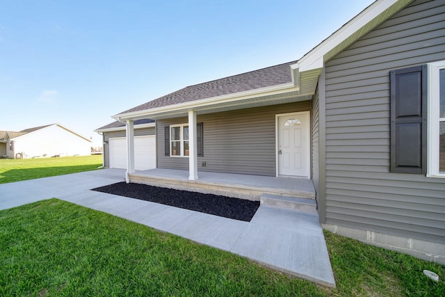 doorway to property featuring covered porch, a yard, and a garage