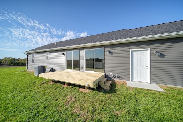 back of property with a lawn, a wooden deck, and central air condition unit