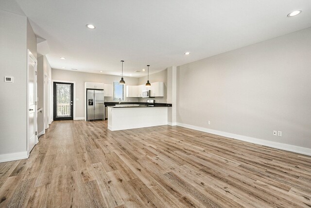 unfurnished living room featuring light hardwood / wood-style floors and sink