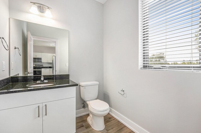 bathroom featuring hardwood / wood-style flooring, vanity, and toilet