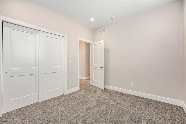 unfurnished bedroom featuring a closet and carpet floors