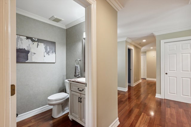 bathroom with hardwood / wood-style flooring, vanity, toilet, and crown molding