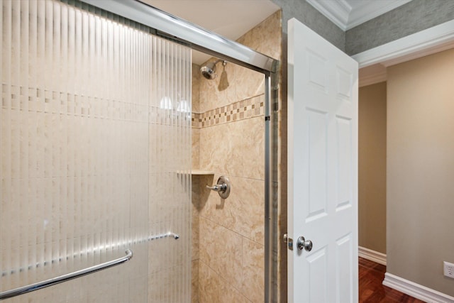 bathroom featuring crown molding and a shower with shower door