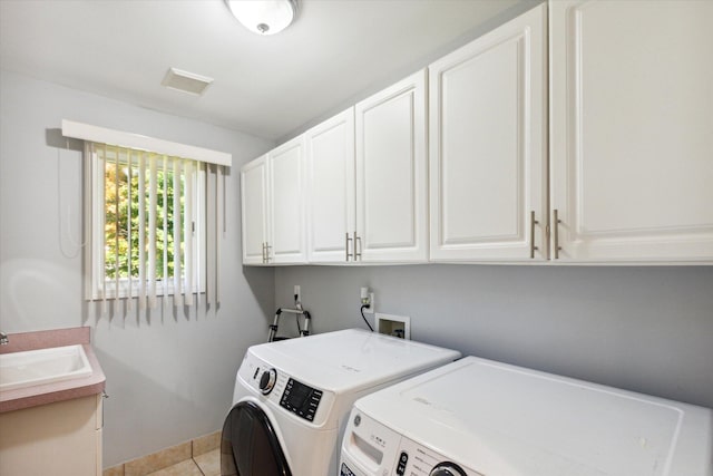 laundry room with washer and clothes dryer, cabinets, light tile patterned floors, and sink