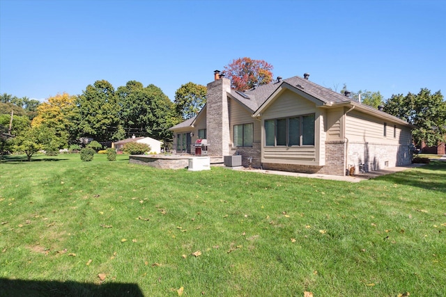 rear view of house with a yard and cooling unit