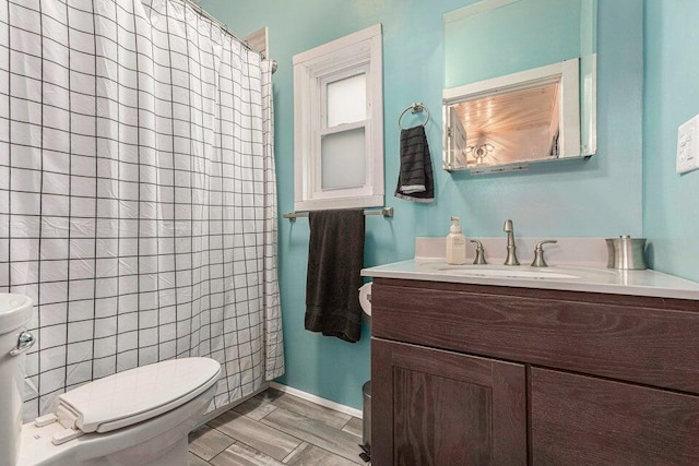 bathroom with vanity, toilet, wood-type flooring, and walk in shower