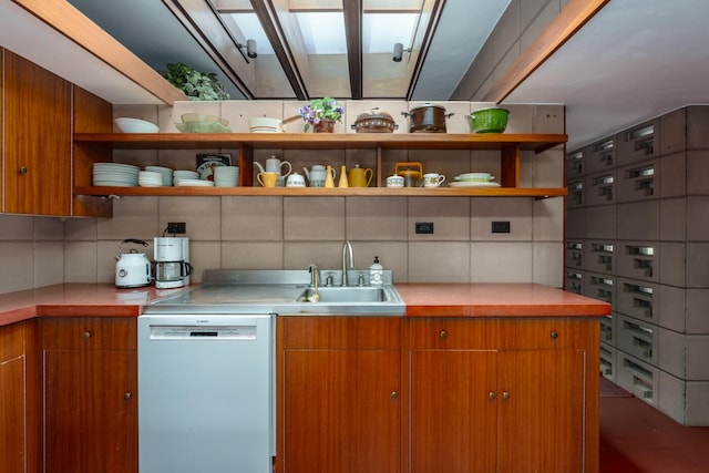 kitchen featuring decorative backsplash, white dishwasher, and sink