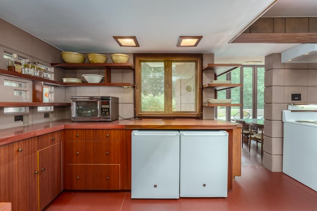 kitchen featuring white refrigerator, washer / dryer, and backsplash
