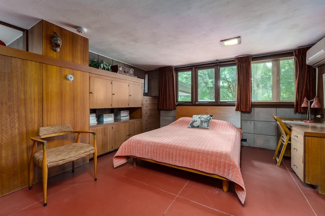 bedroom featuring a textured ceiling and a wall mounted air conditioner