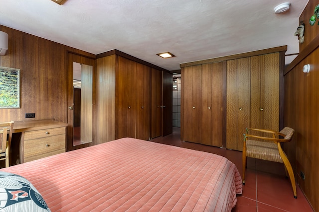 bedroom featuring an AC wall unit, wood walls, and a textured ceiling