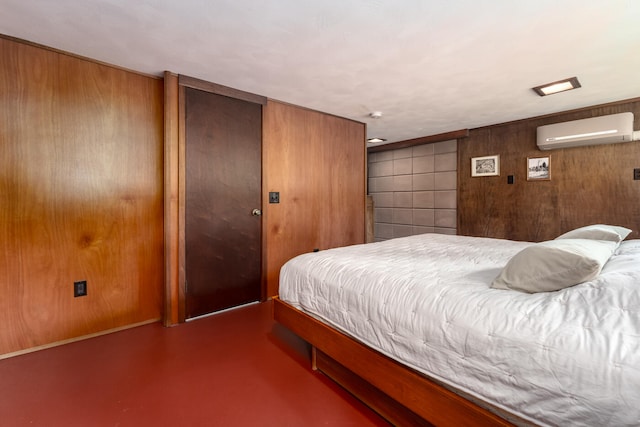 bedroom with wood walls, concrete flooring, and a wall mounted AC