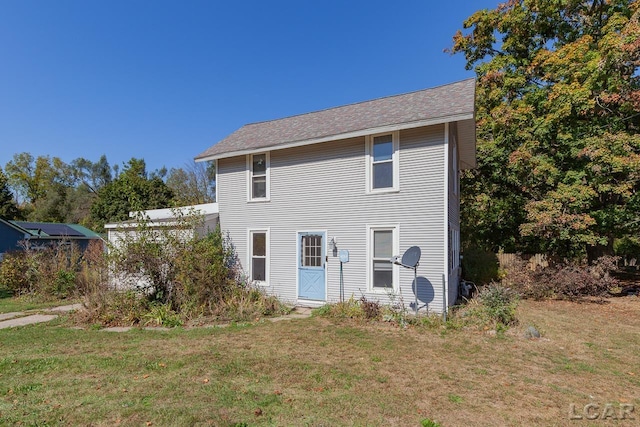 rear view of property featuring a yard