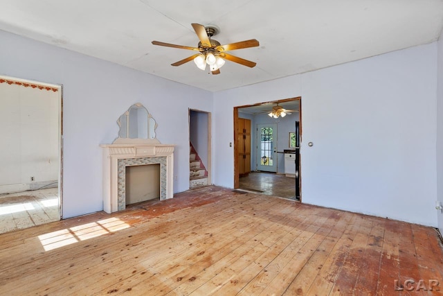 unfurnished living room with wood-type flooring and ceiling fan