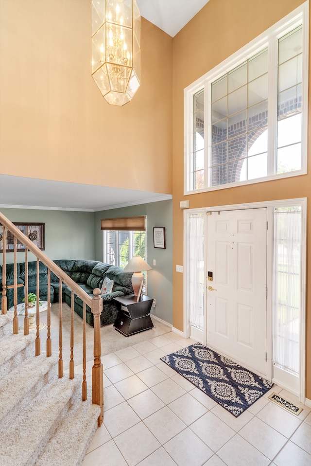 foyer entrance featuring light tile patterned flooring, a high ceiling, and a notable chandelier