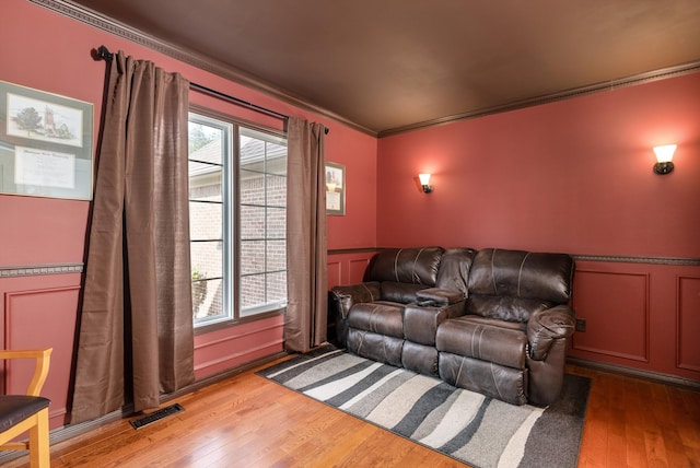 cinema with crown molding and light hardwood / wood-style floors