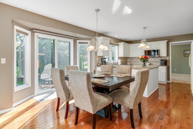 dining area with a chandelier, light hardwood / wood-style flooring, and a healthy amount of sunlight